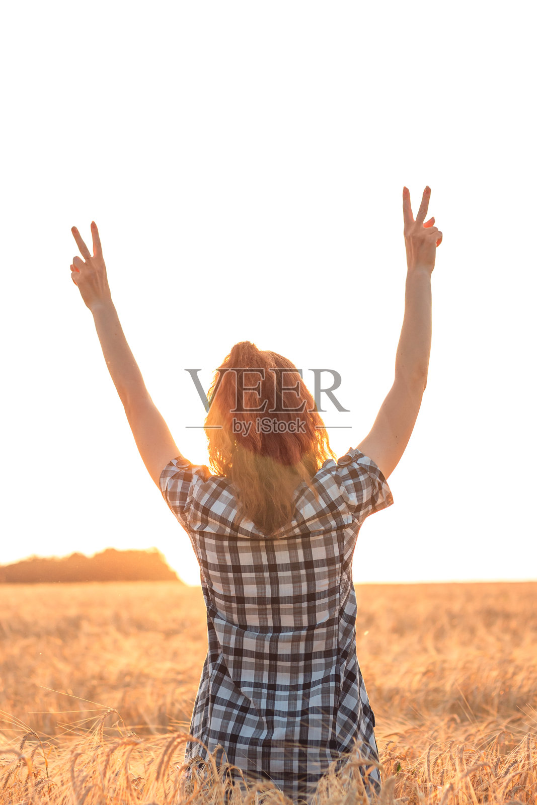 黄昏时分,麦田里伸出双臂的女孩照片摄影图片