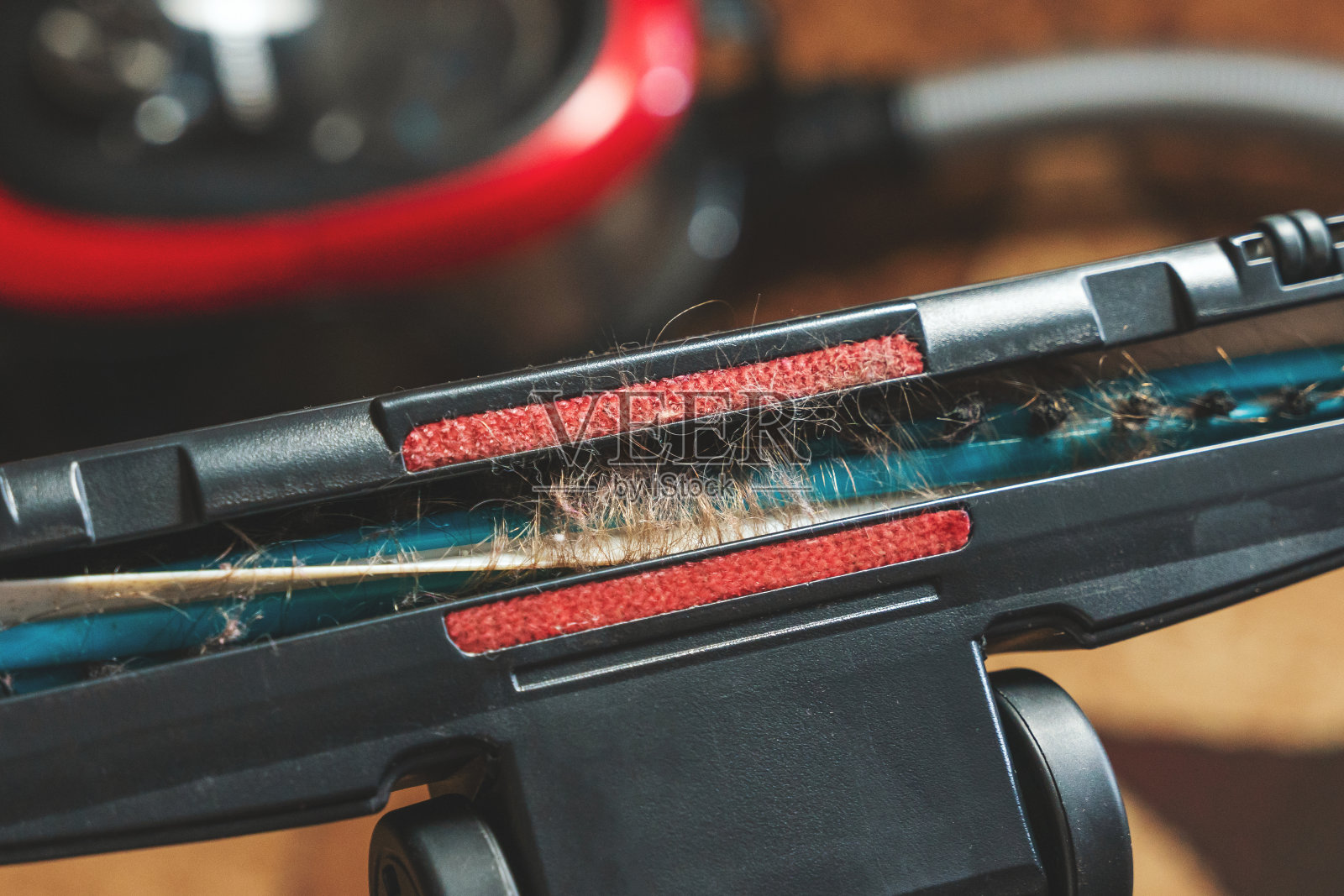 打扫房间时,长发缠在吸尘器的涡轮刷上照片摄影图片