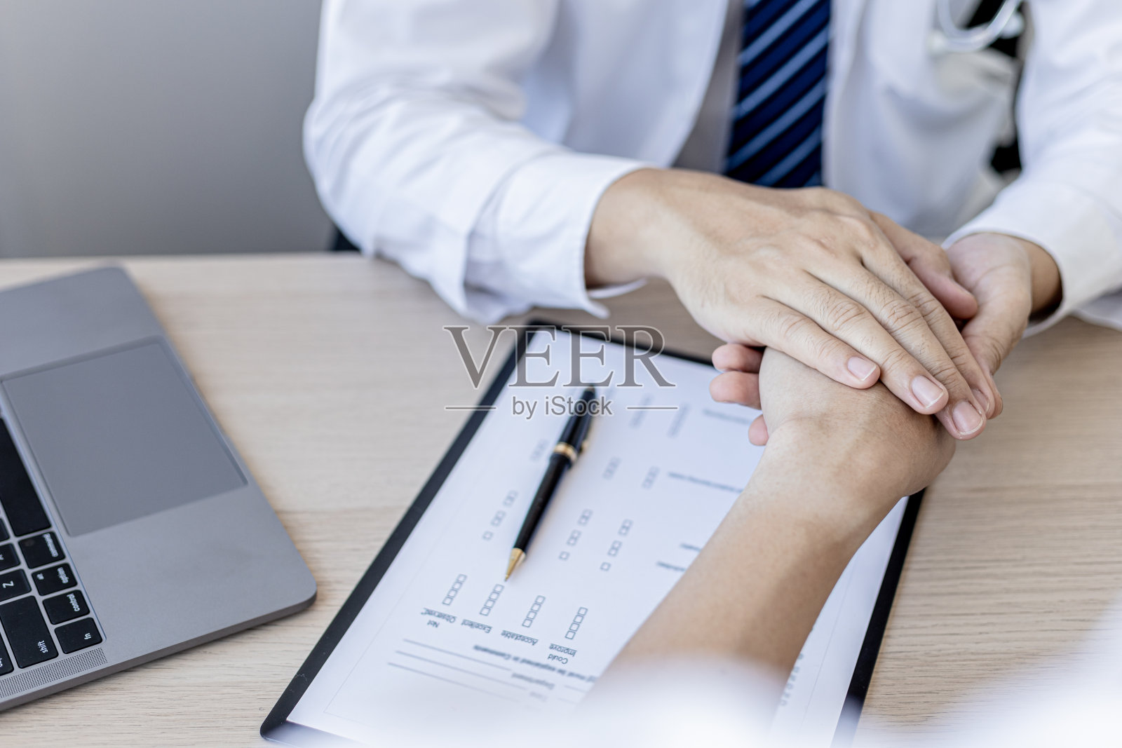 诊断结果出来后,医生与病人握手鼓励,病人在早期发现了严重的疾病。疾病诊断的概念。照片摄影图片