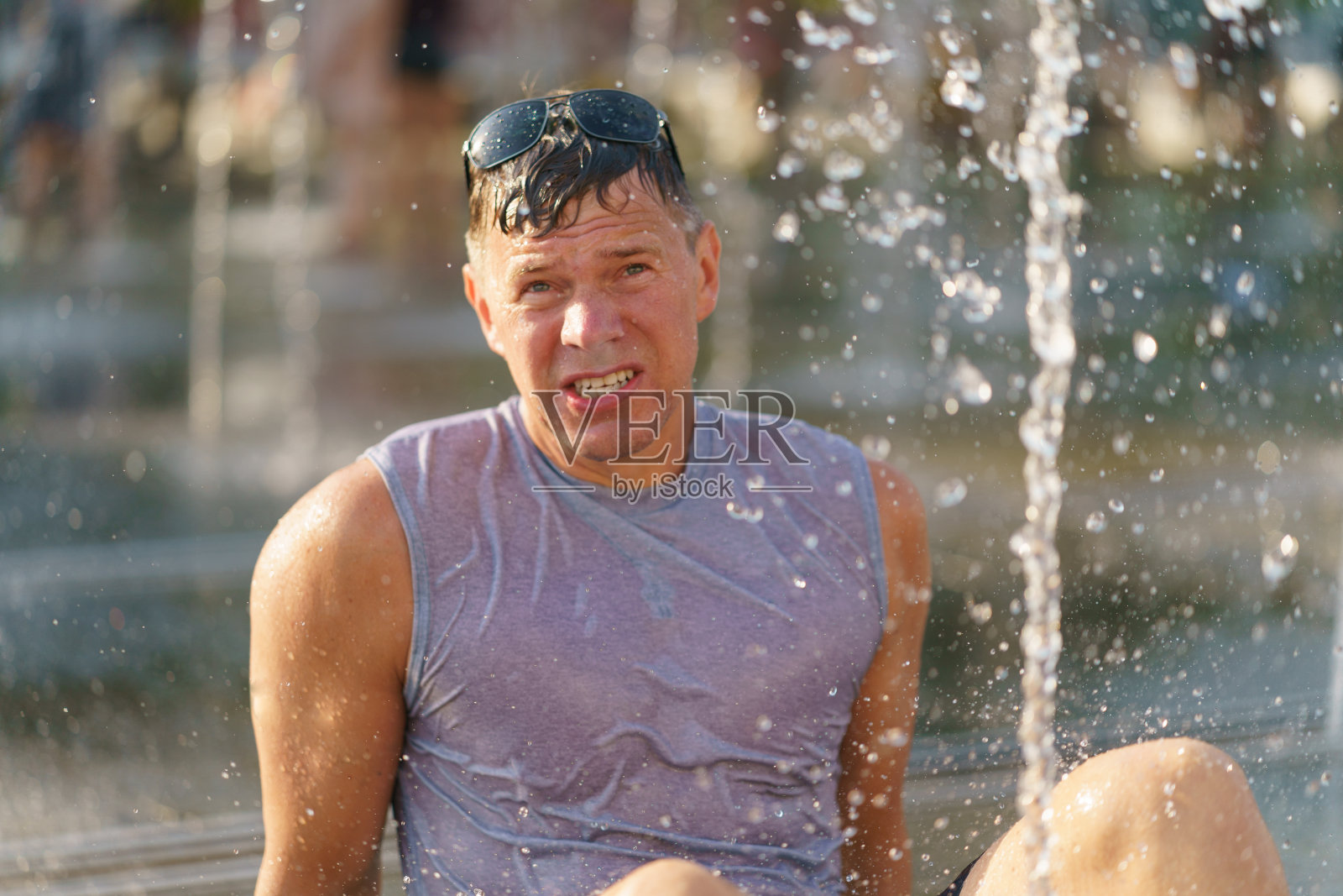 坐在喷泉间的人照片摄影图片