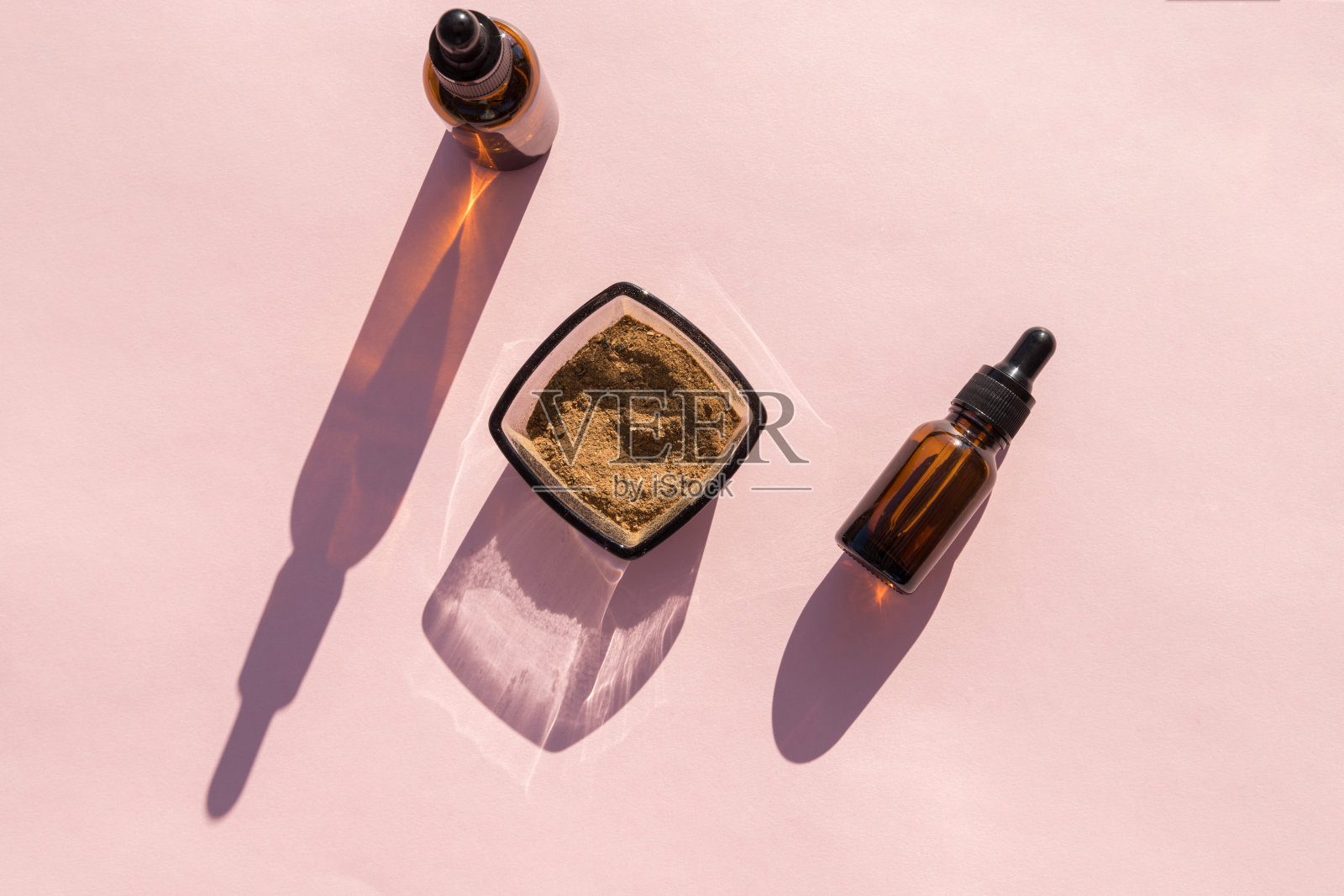 做一些必需品。粉红色背景上有油和蘑菇的瓶子。在化妆品中使用蘑菇的概念。一个地方,你的标志。完美的美容博客。断然。照片摄影图片