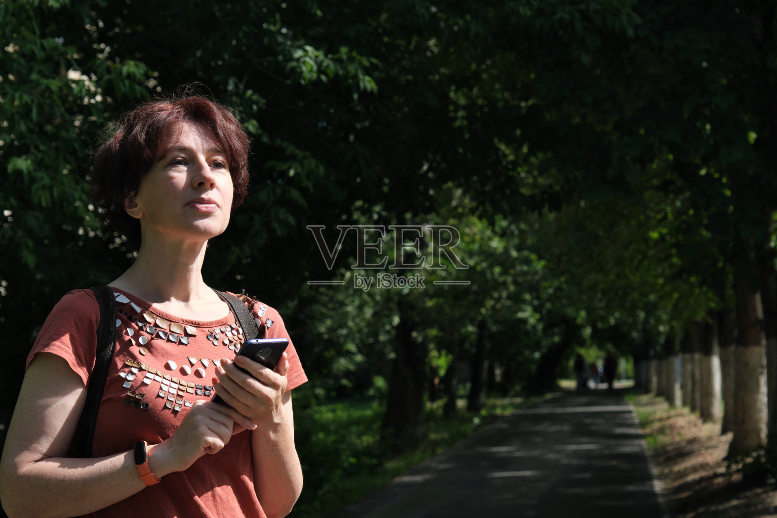 成熟的女人站在城市街道上使用智能手机照片摄影图片