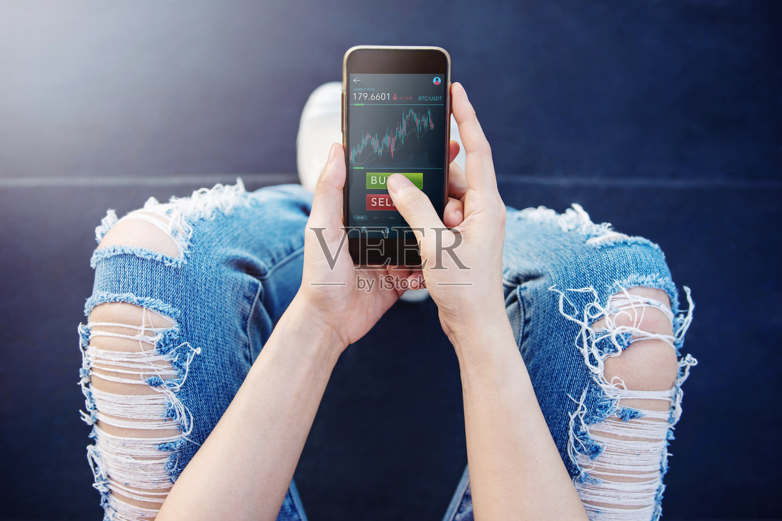 Cryptocurrency投资概念。一名年轻女子在户外用手机在线交易比特币照片摄影图片