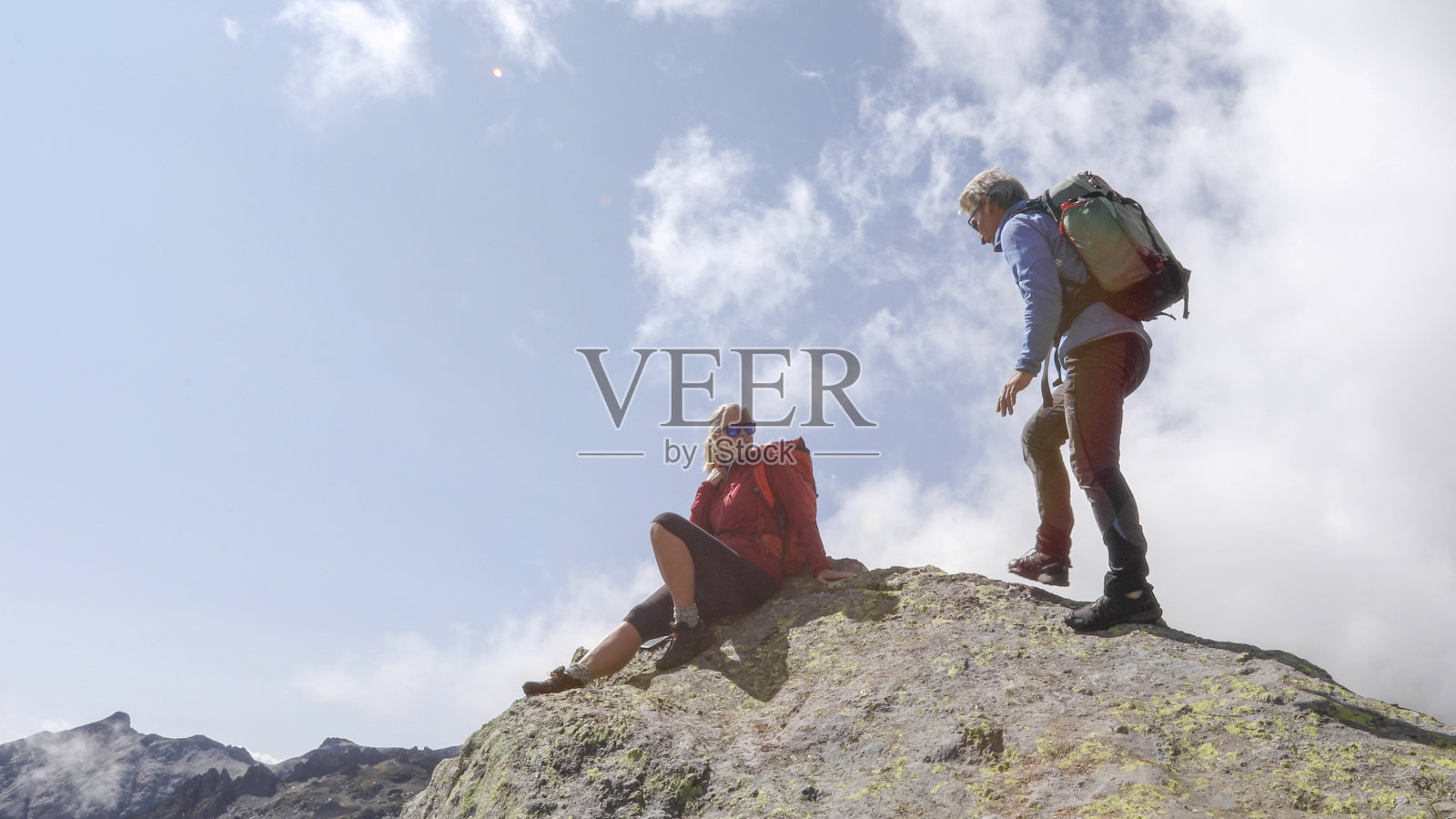 成熟的徒步旅行夫妇在阳光明媚的山脊上放松照片摄影图片