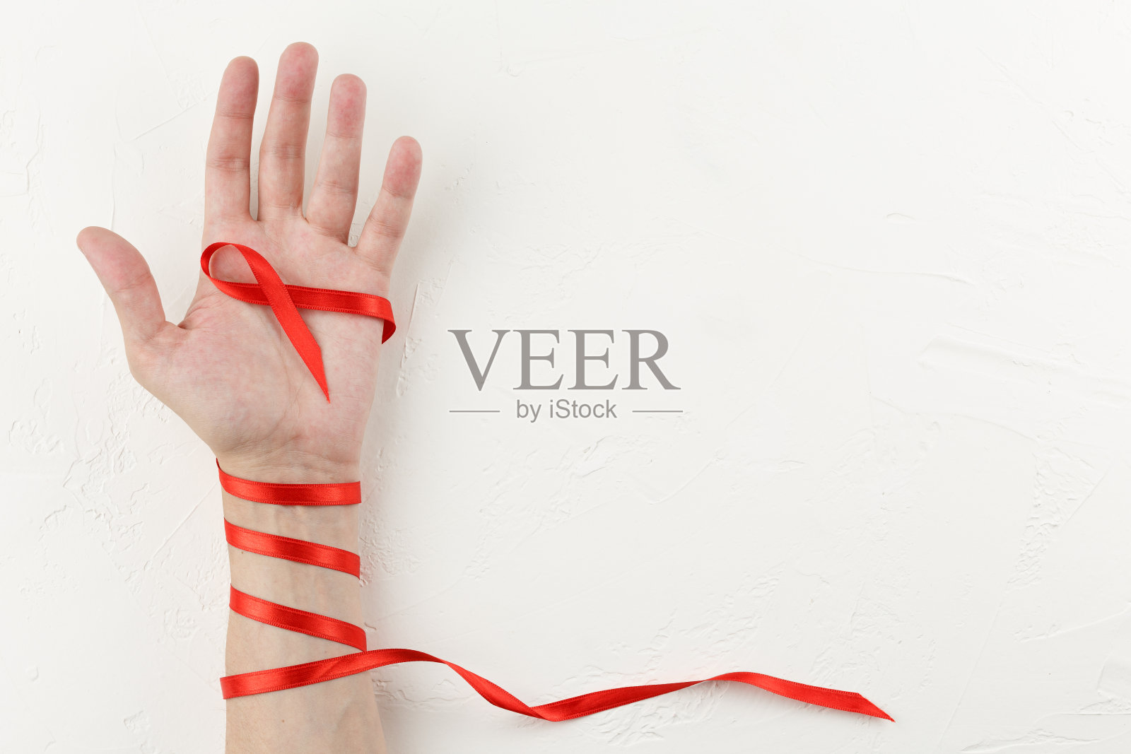 手臂上缠着癌症红丝带照片摄影图片