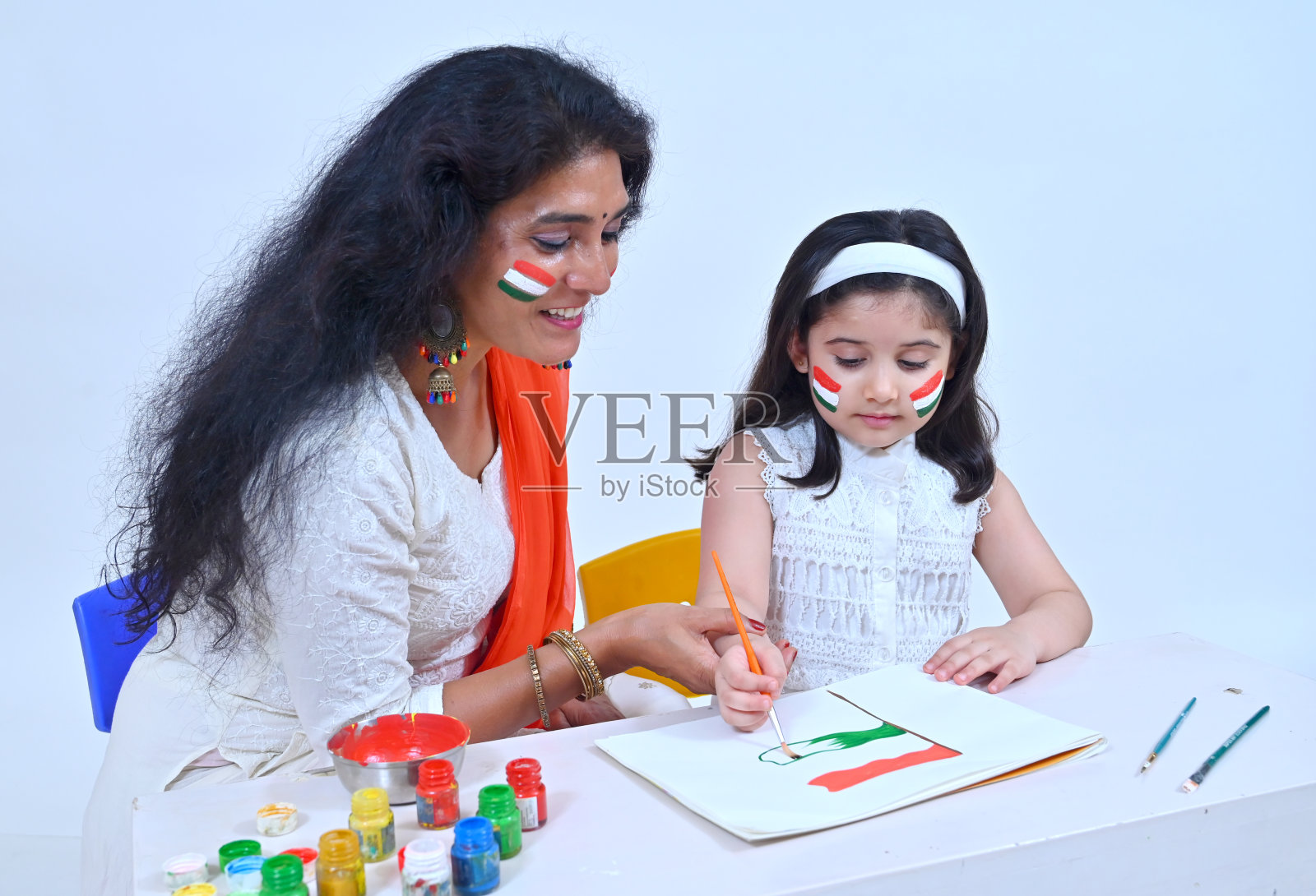 在印度独立日庆祝活动中,老师教孩子如何制作和着色印度国旗照片摄影图片