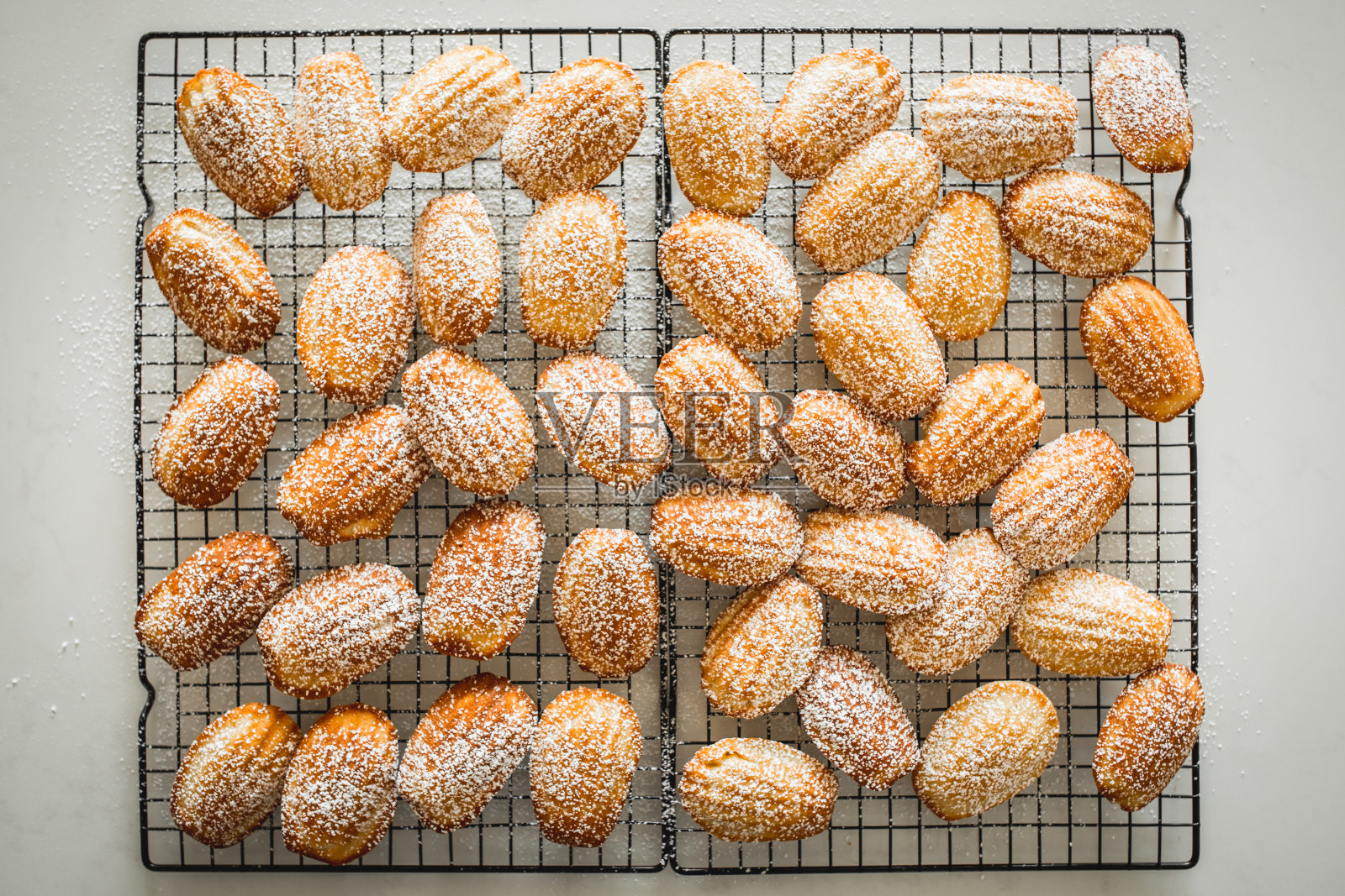 玛德琳蛋糕在铁丝架冷却和分层托盘展示照片摄影图片