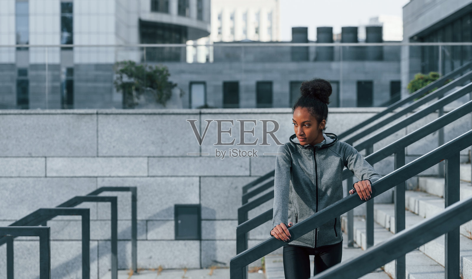 穿着运动服的年轻非洲裔美国妇女白天在户外锻炼照片摄影图片