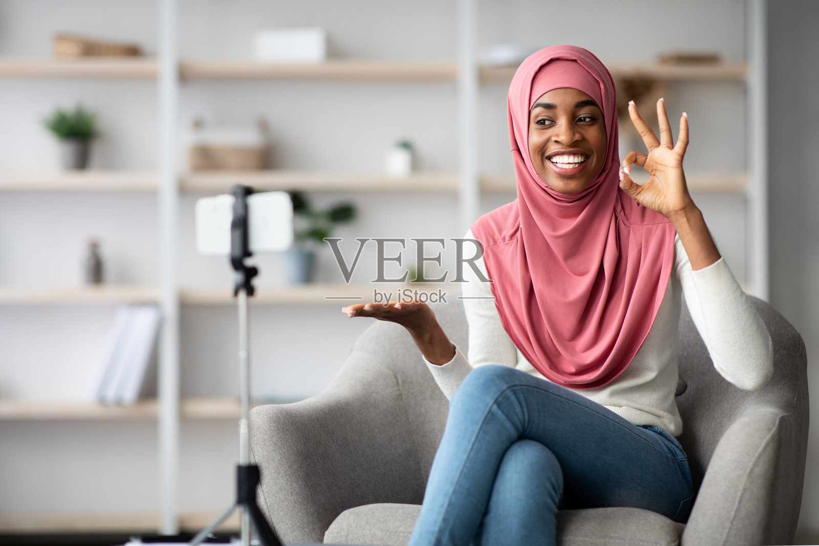 戴着头巾的快乐黑人穆斯林博主在镜头前拍摄视频照片摄影图片