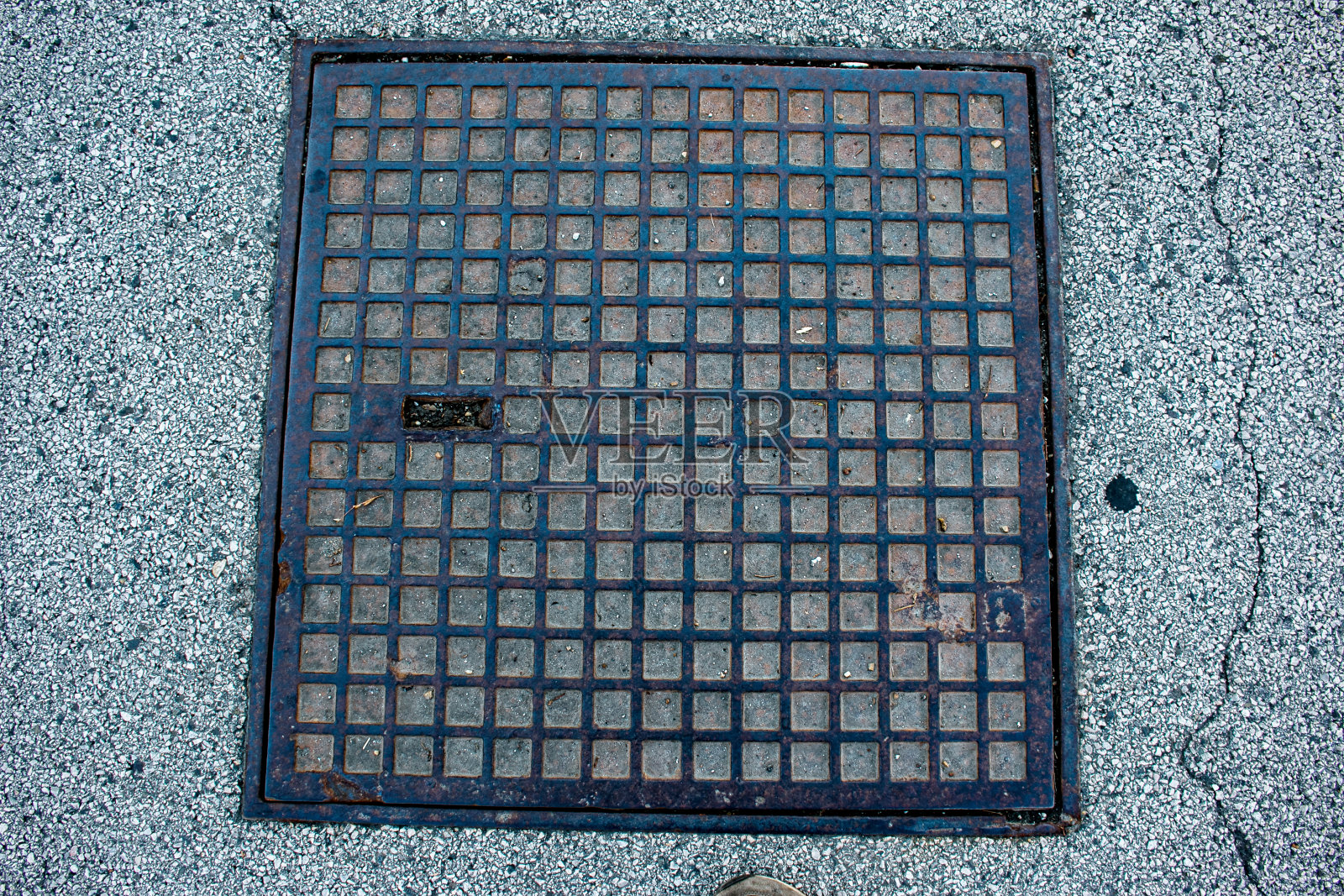 城市柏油路上用于交通的方形舱口。特写照片。照片摄影图片