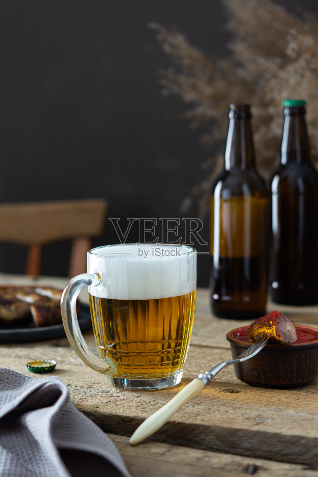 杯子上有啤酒和泡沫叉子上有香肠照片摄影图片