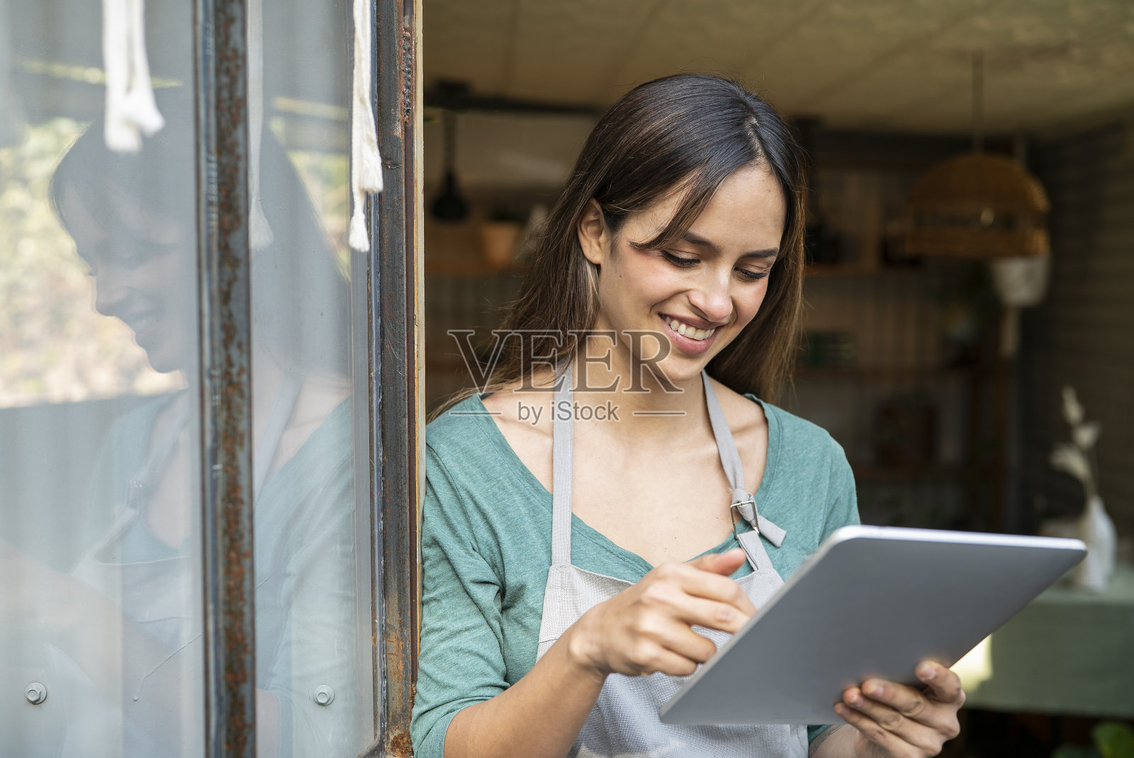 微笑的年轻企业家手持电子平板电脑站在门口照片摄影图片