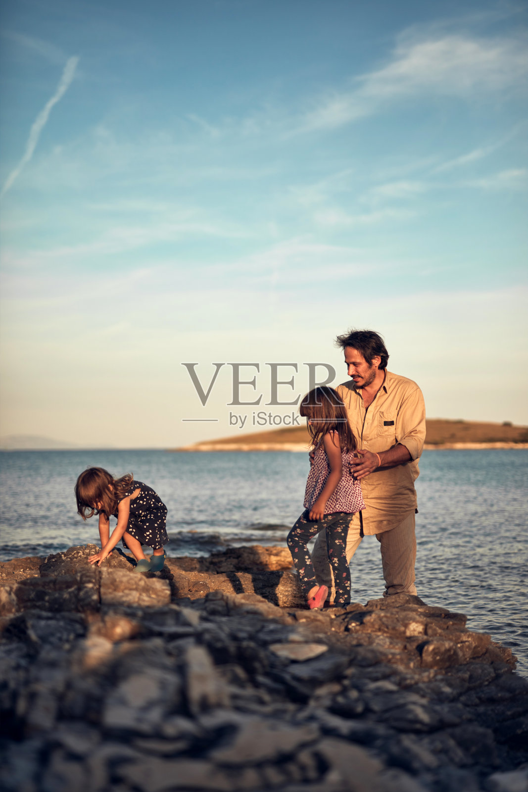 父亲和女儿们在海边玩耍照片摄影图片