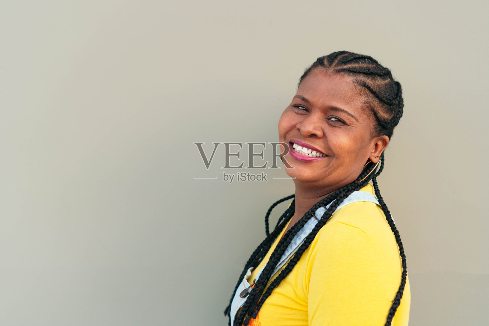 一个梳着辫子的黑人女人看着镜头照片摄影图片