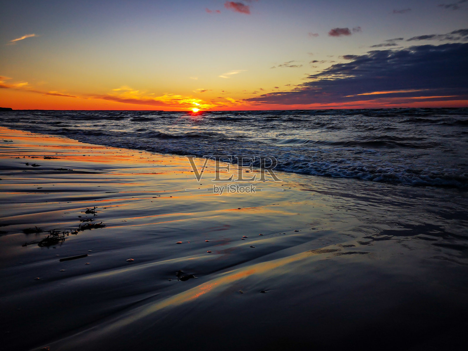 落日倒映在波罗的海和潮湿的沙滩上照片摄影图片