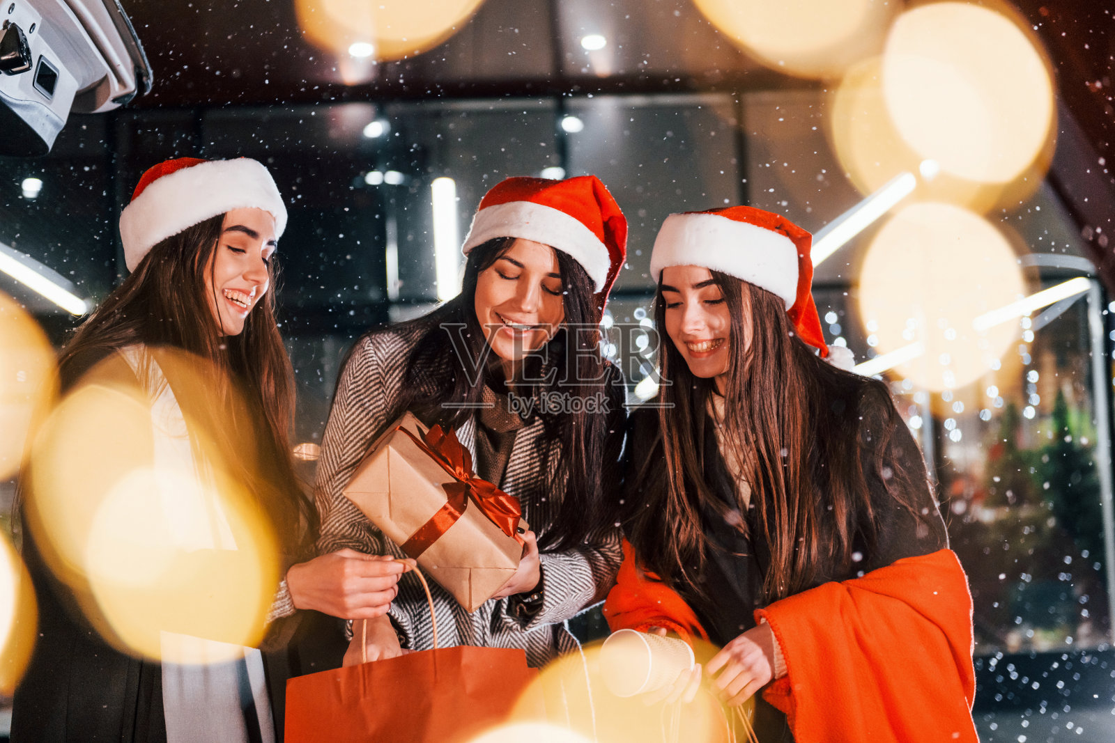 三个快乐的女人一起在户外度过圣诞假期。新年观念照片摄影图片
