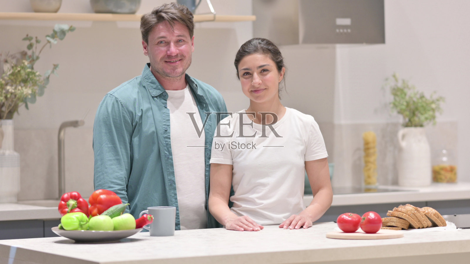 混血儿夫妇在厨房里点头表示同意照片摄影图片