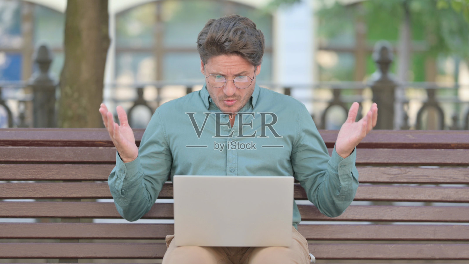 中年男子在户外使用笔记本电脑时对损失的反应照片摄影图片