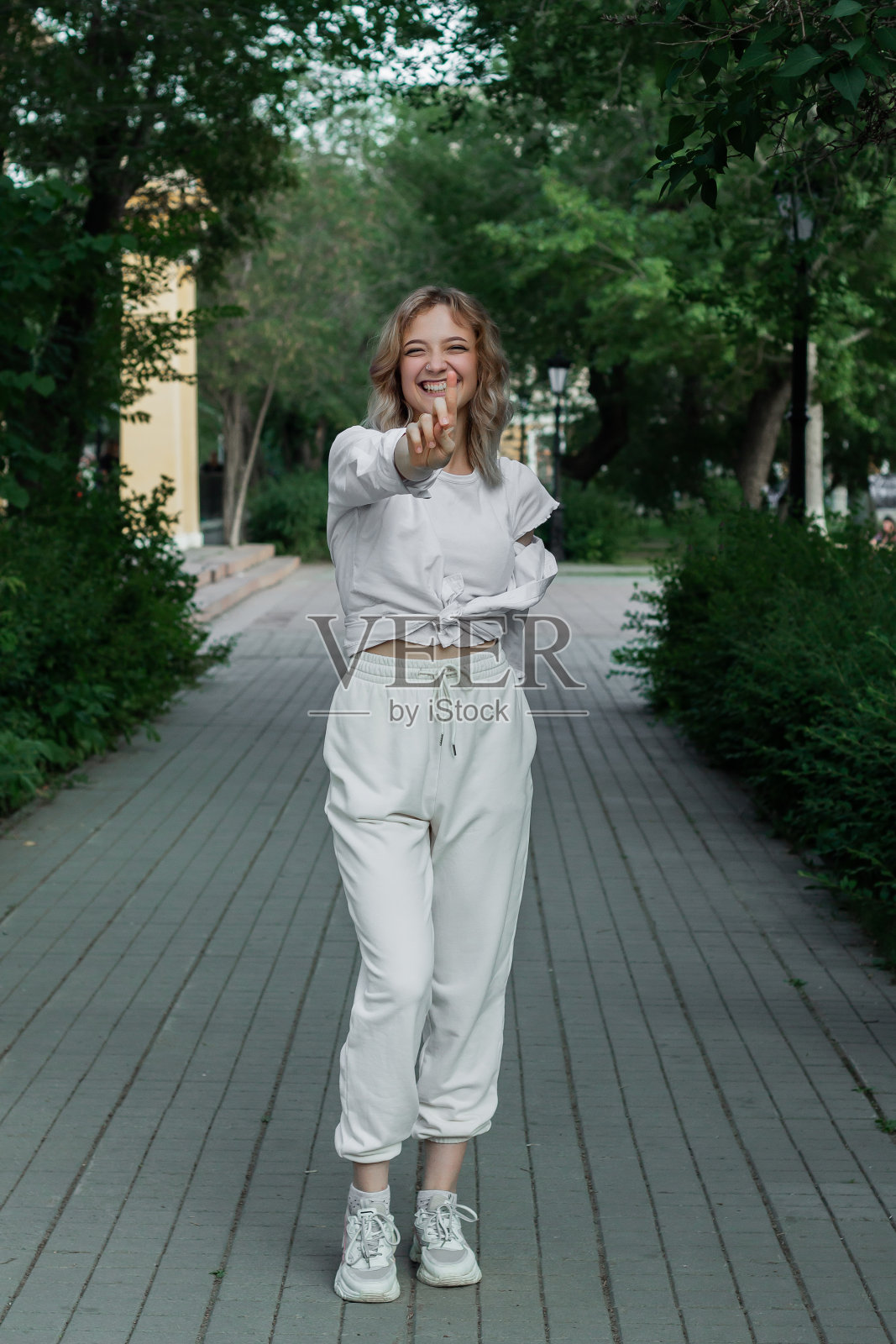 一个穿着白色衣服的美丽年轻女子的肖像在城市的小巷里照片摄影图片