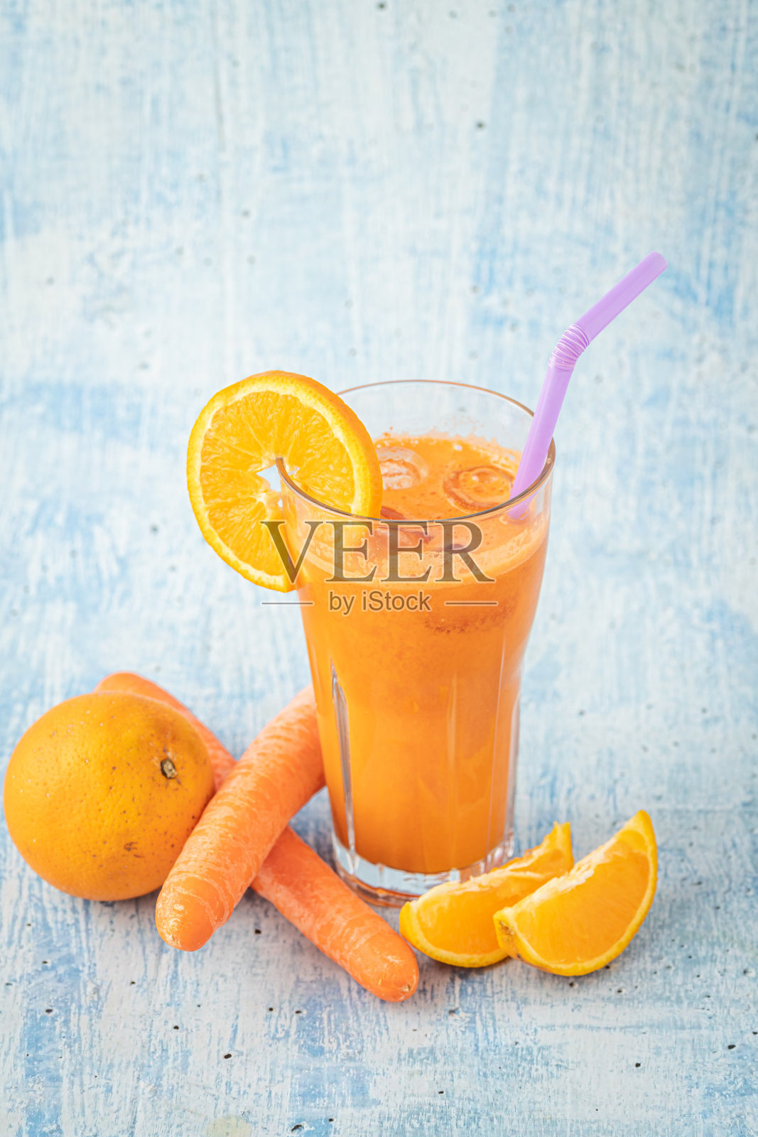 蓝桌上放胡萝卜和橙汁照片摄影图片