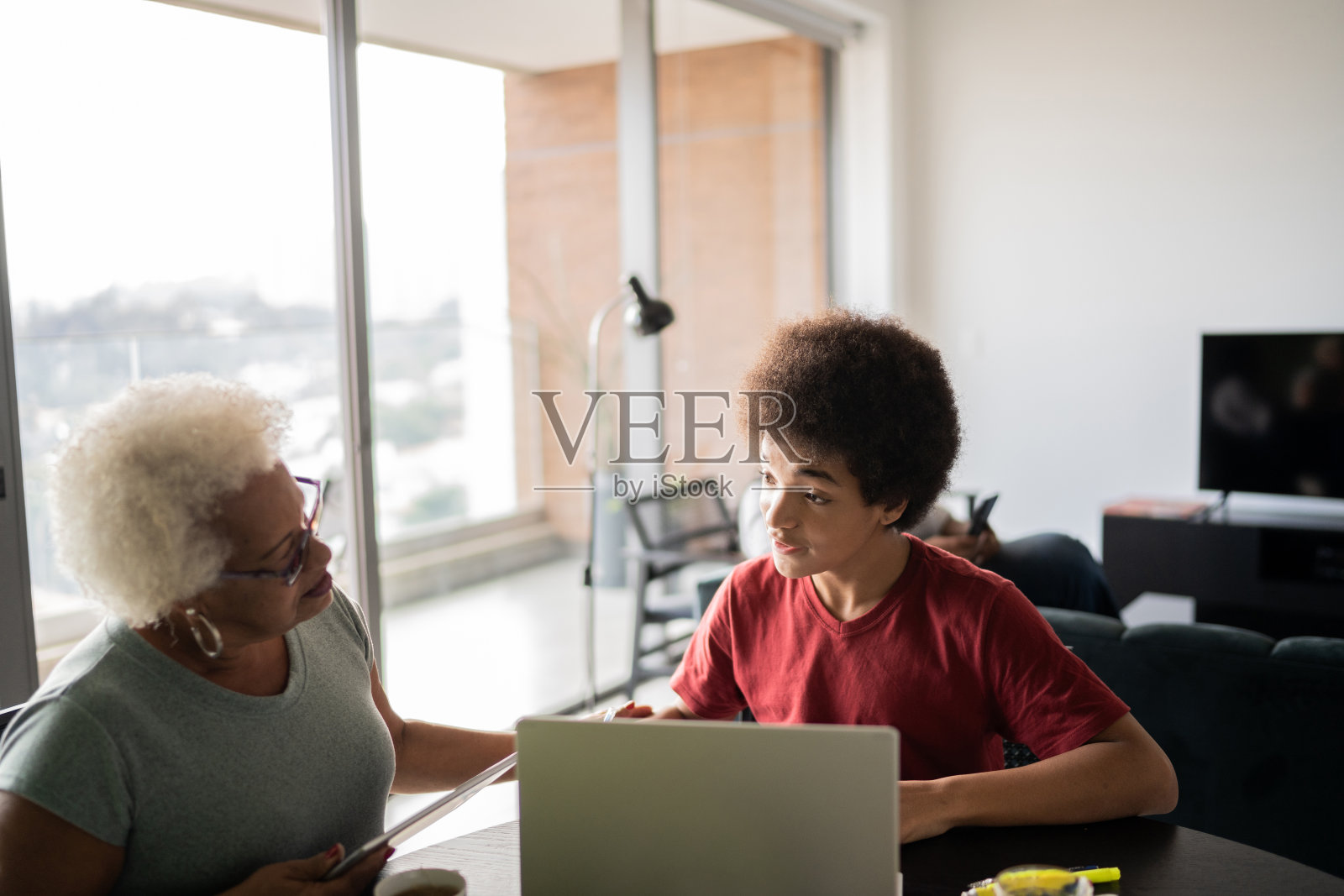 奶奶帮助孙子做作业照片摄影图片