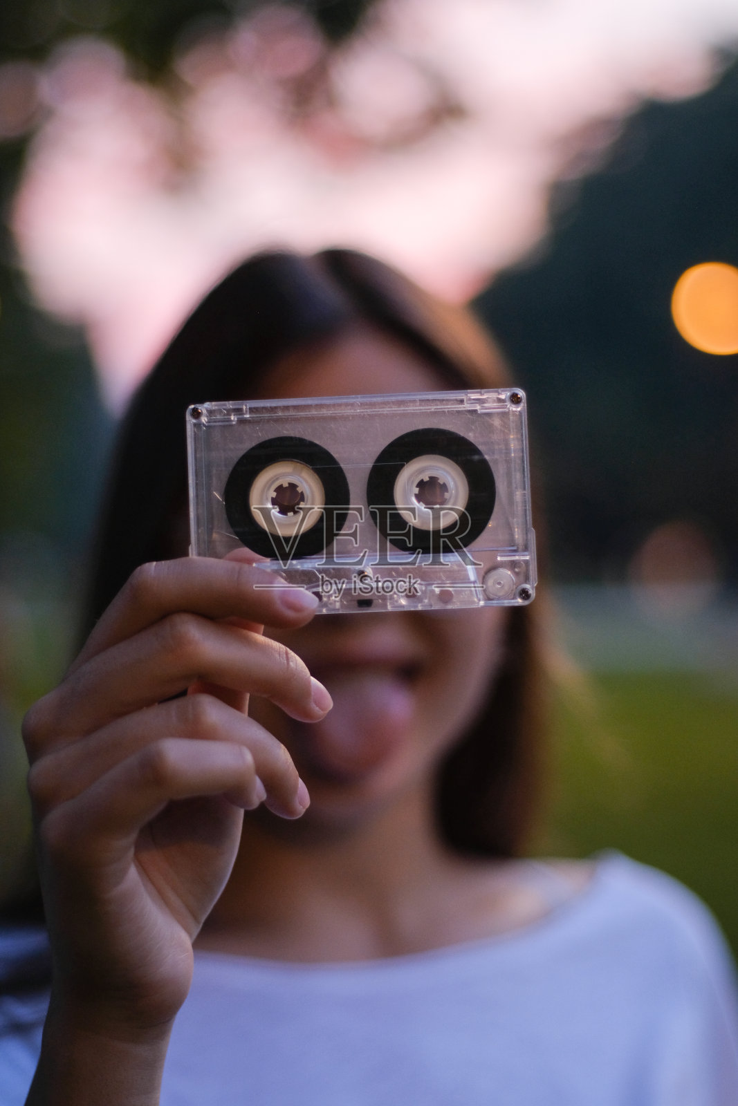 年轻的少女用磁带做鬼脸照片摄影图片