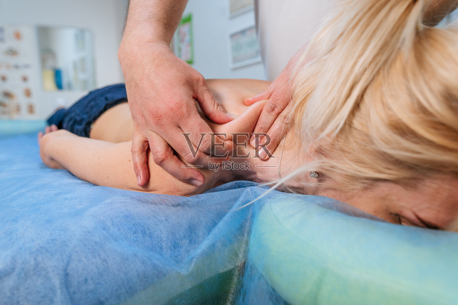 康复中心健身房的按摩师给女病人做按摩的特写照片摄影图片