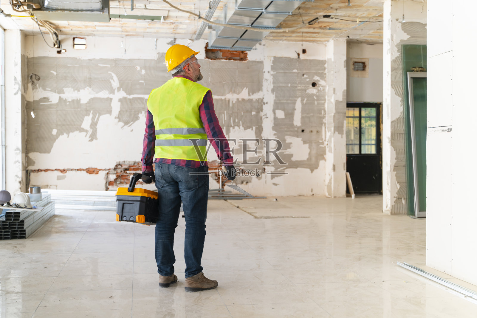 建筑工人在施工现场拿工具箱照片摄影图片