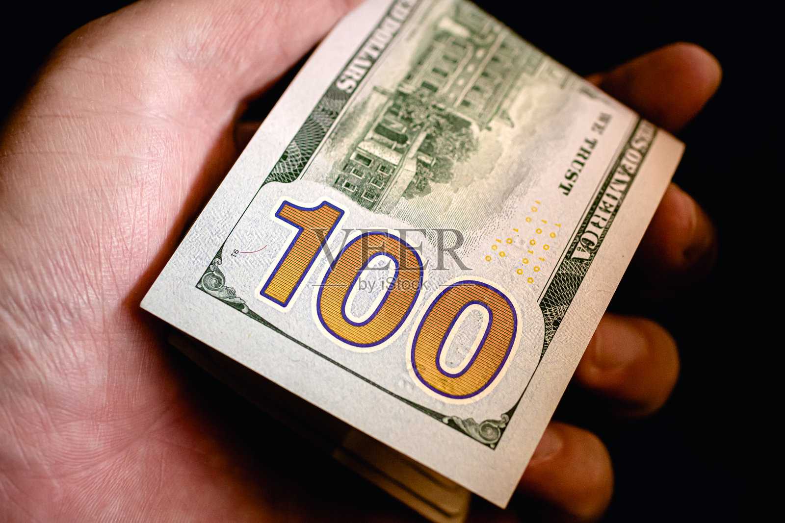 现金-美元(USD)。一个拿着美钞的男人。近距离的照片。经济学和金融概念。照片摄影图片