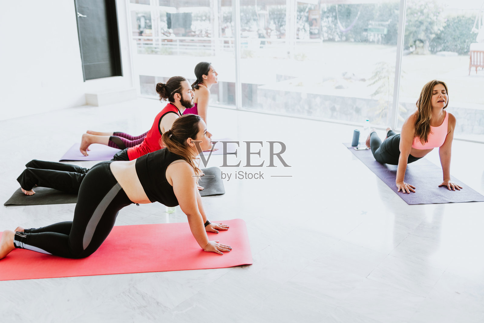 年轻的墨西哥人在拉丁美洲和教练一起练习瑜伽伸展运动照片摄影图片