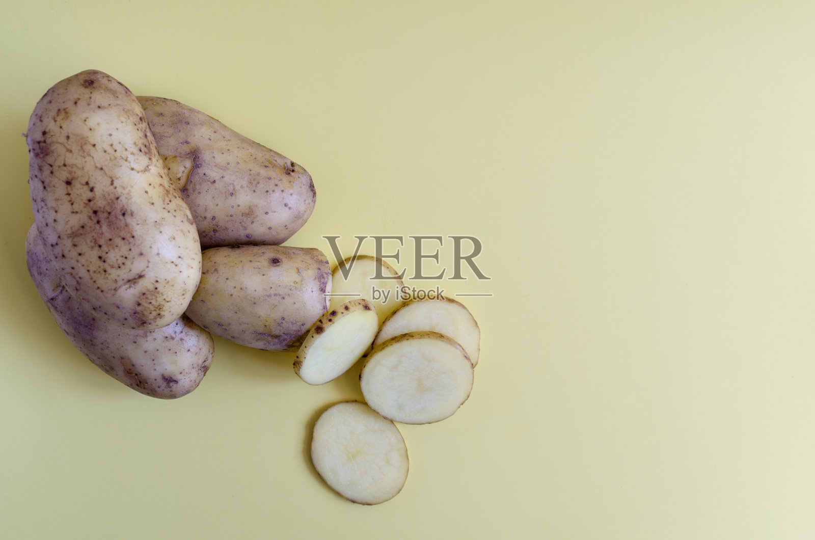 土豆块茎和半个土豆在彩色背景上。土豆在彩色背景的kopi空间照片摄影图片