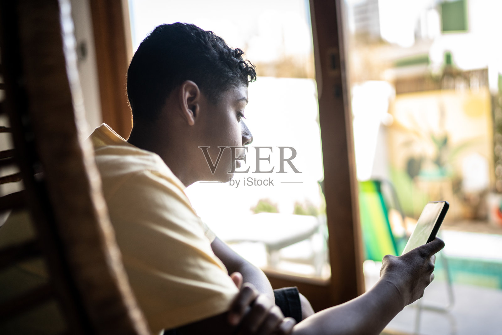 十几岁的男孩在家用智能手机照片摄影图片