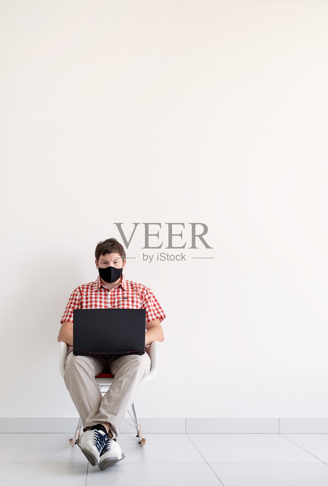 戴着防护面具的年轻人在网上学习,用笔记本电脑保持社交距离照片摄影图片