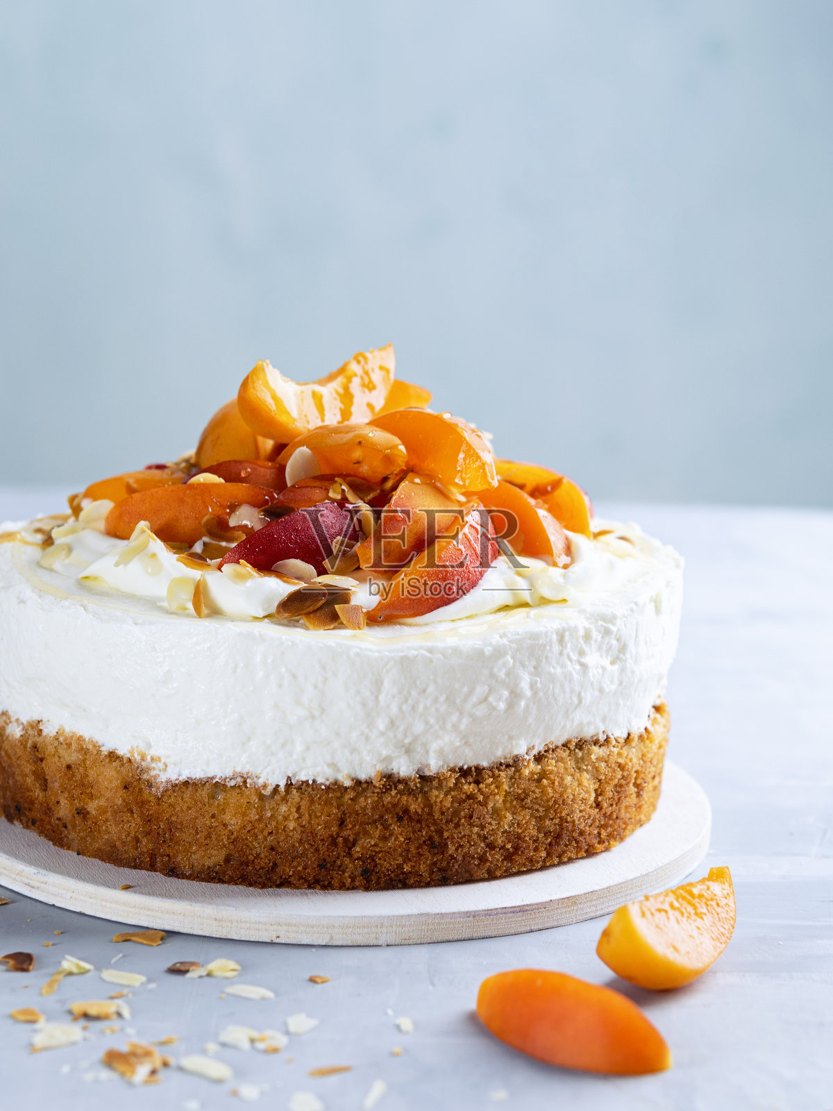 鲜杏芝士蛋糕浅蓝色背景,复制空间。健康的夏季甜点概念。有选择性的重点。照片摄影图片