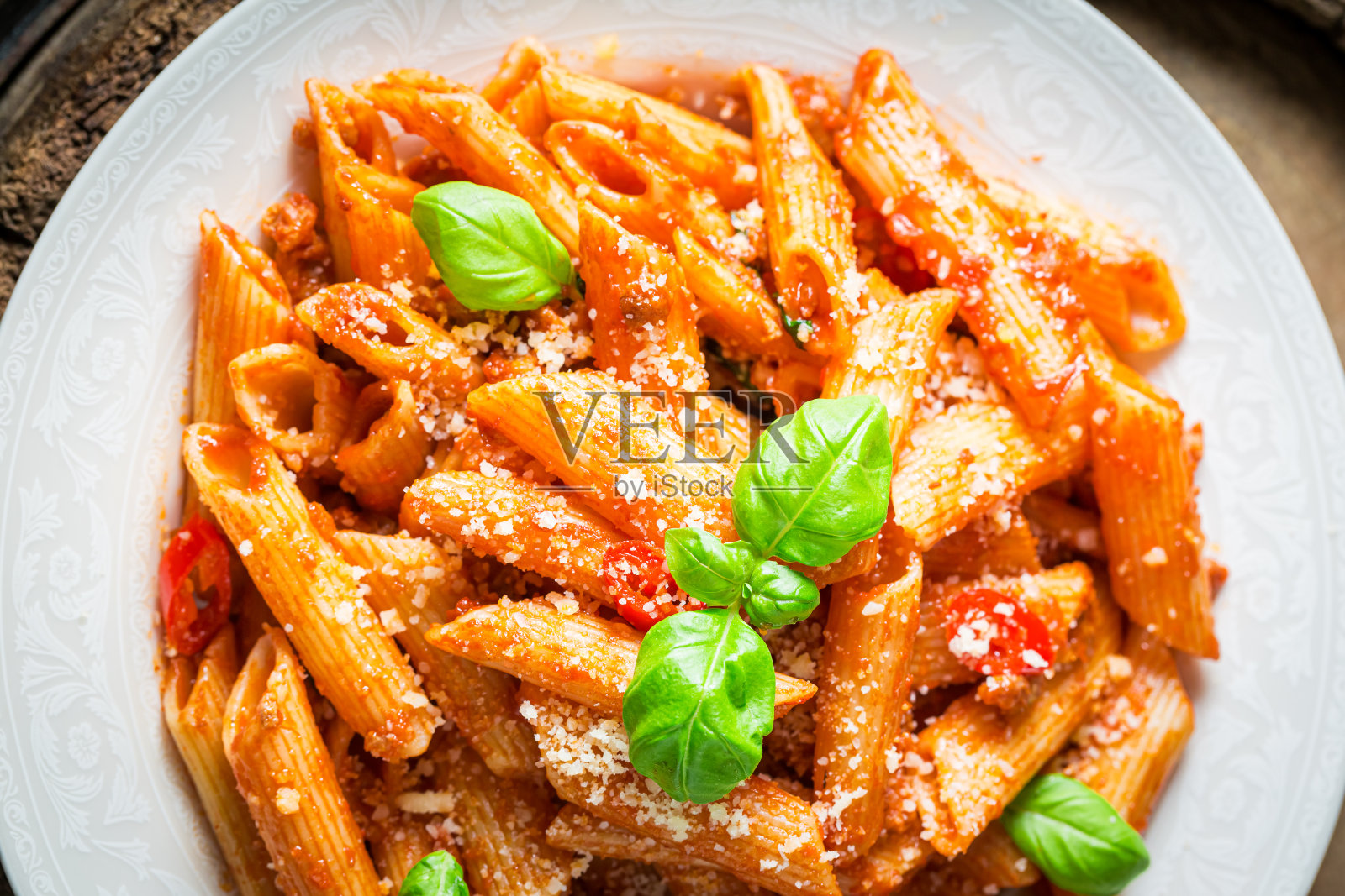 享用帕尔玛干酪和罗勒肉酱通心粉吧。意大利菜。照片摄影图片