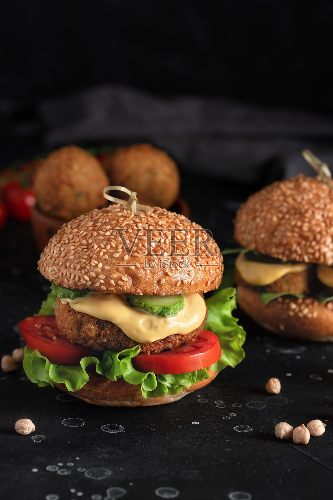 纯素沙拉三明治汉堡,新鲜蔬菜,黑色石头背景。健康饮食的概念。侧视图,选择性聚焦。照片摄影图片