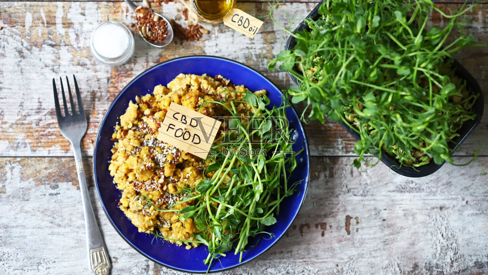 餐盘上标有CBD的食物,包括扁豆和微绿色蔬菜,并添加CBD油。照片摄影图片