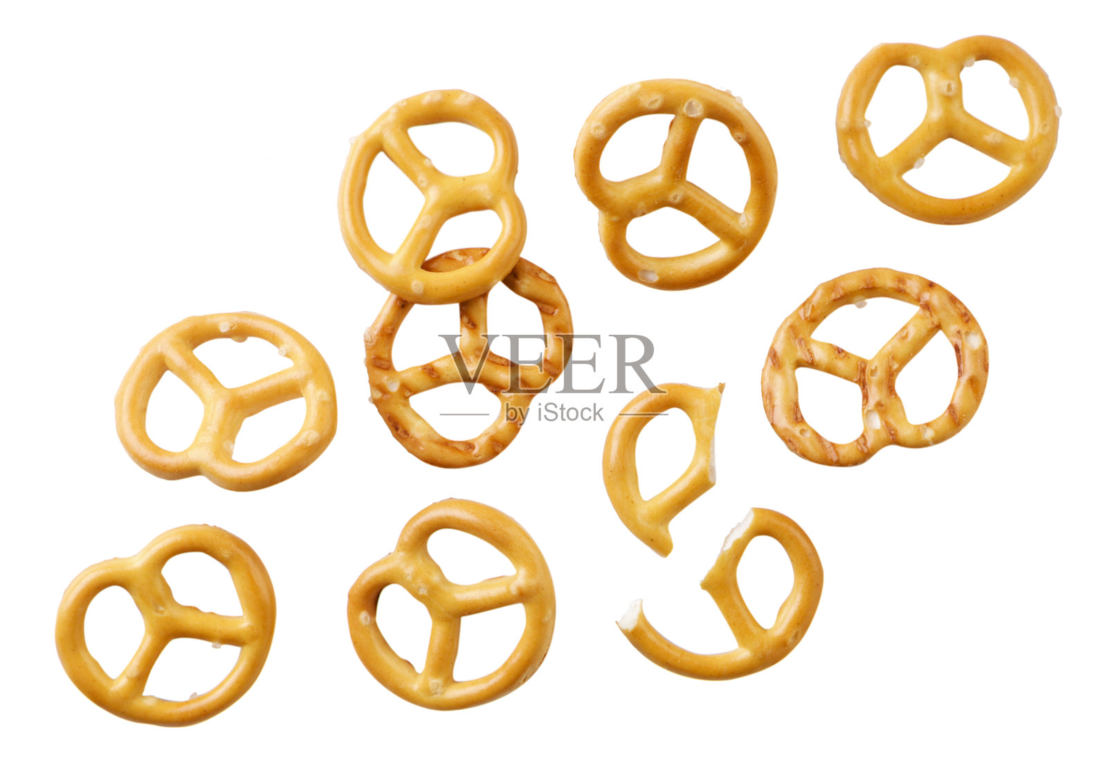 一个椒盐卷饼落在白色背景上,一个椒盐卷饼漂浮在空中。孤立的照片摄影图片