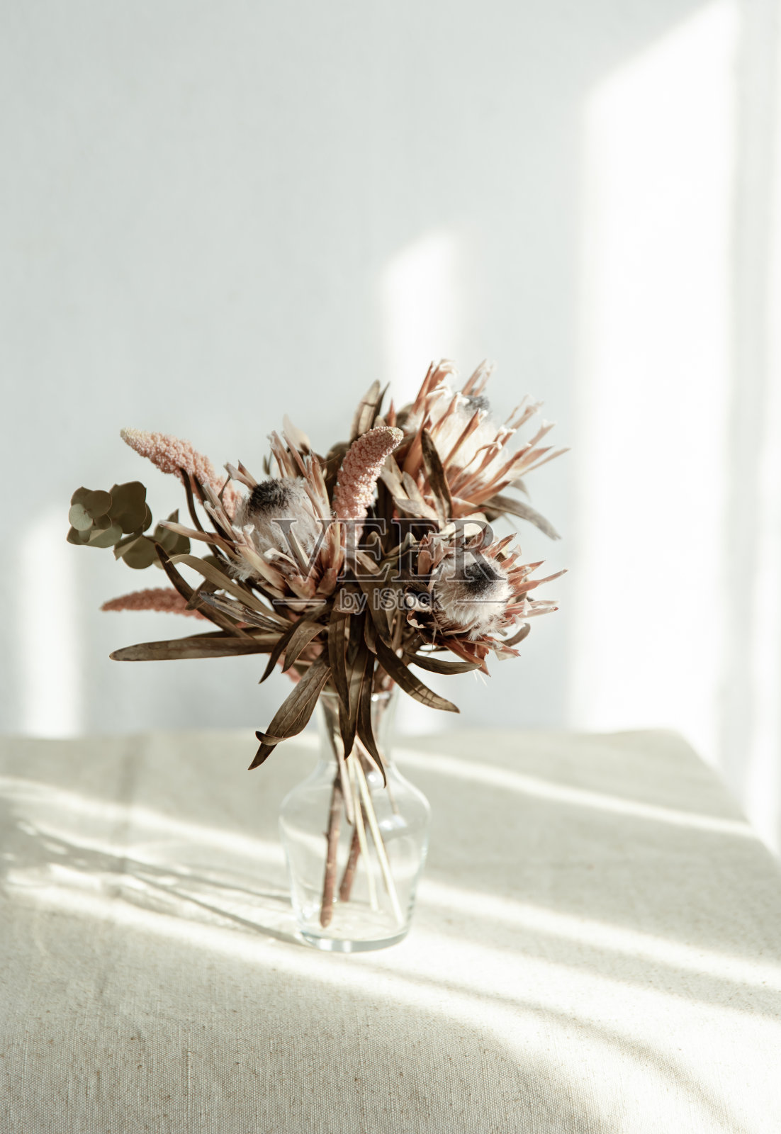 玻璃花瓶里的干花。照片摄影图片