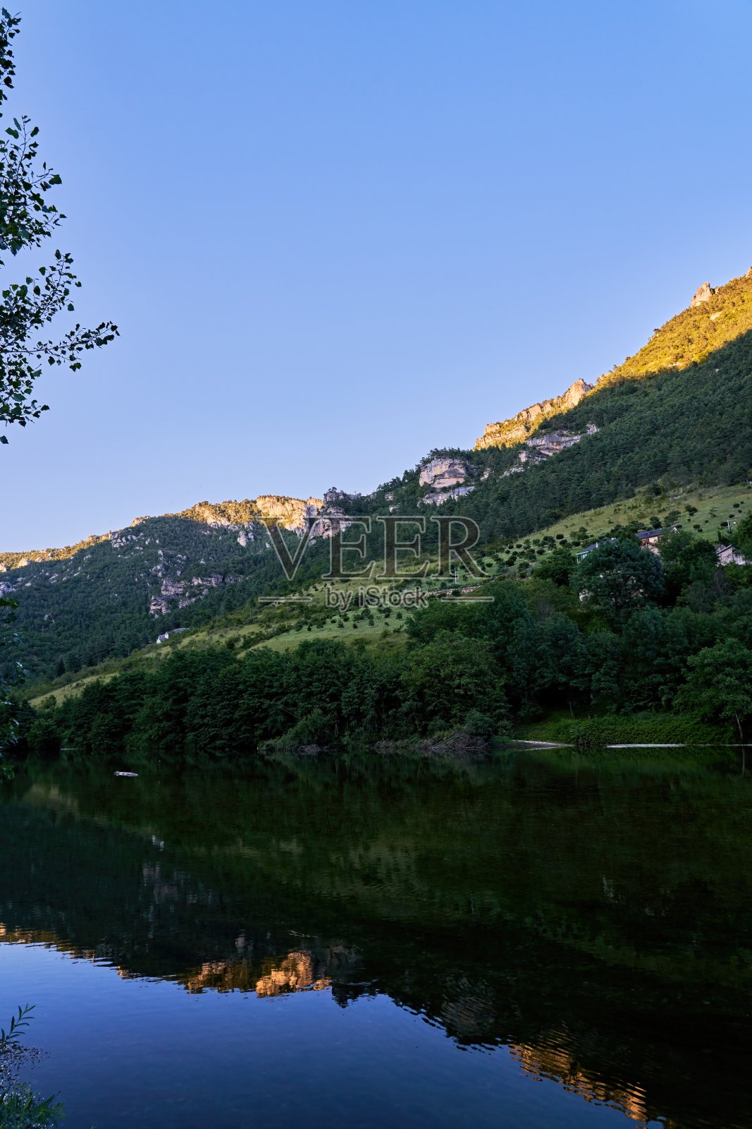 日落时分,塔恩峡谷的悬崖倒映在塔恩河的水面上照片摄影图片