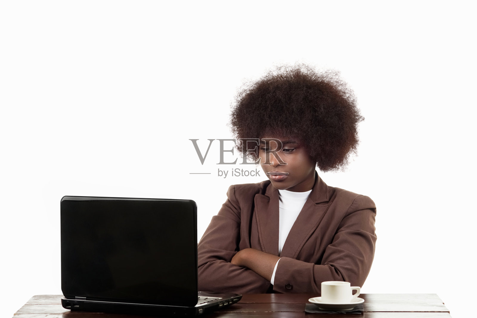 年轻的西班牙裔黑人女商人,留着非洲式发型,用愤怒的手势看着她的笔记本电脑,背景是白色的照片摄影图片