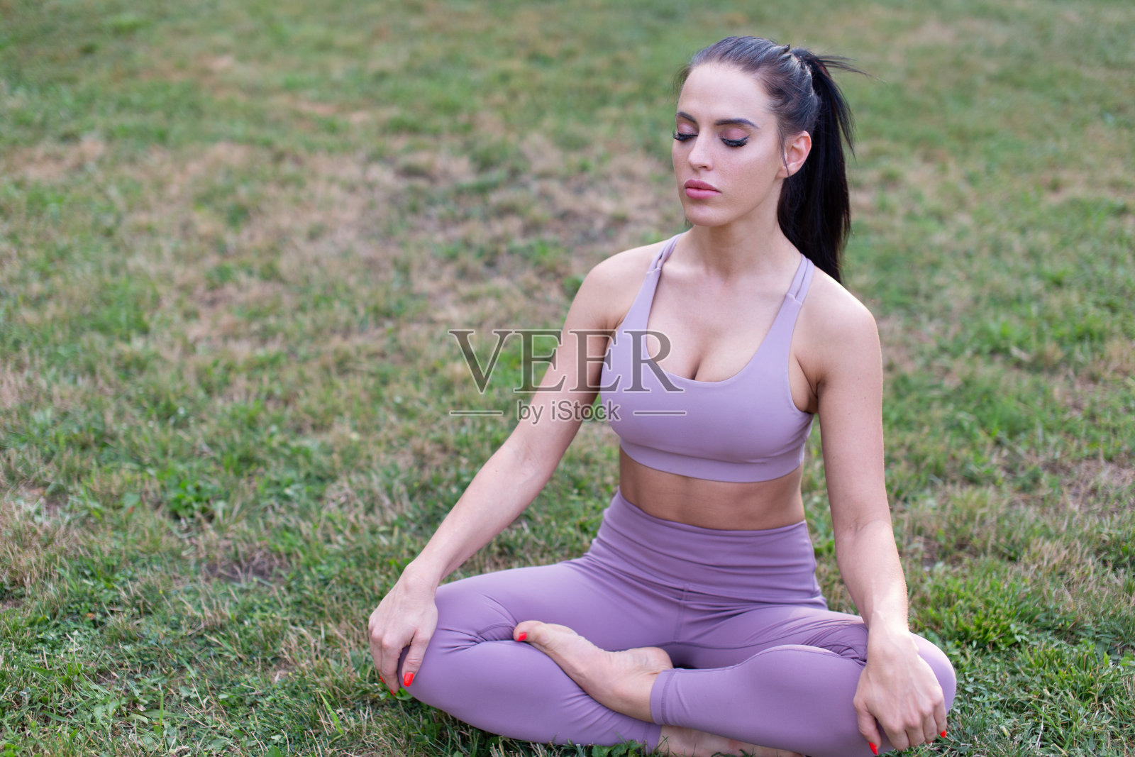 荷花中的年轻女子坐在花园里冥想照片摄影图片