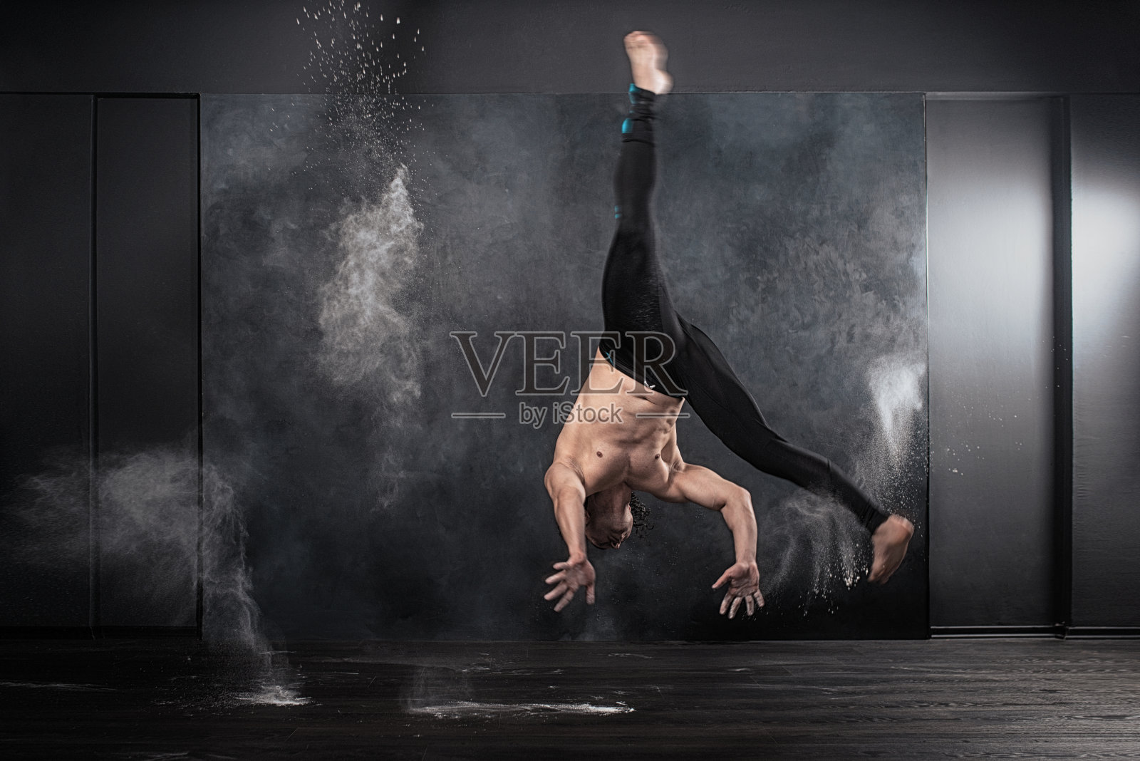 卡波耶拉表演者在尘土中翻滚。照片摄影图片