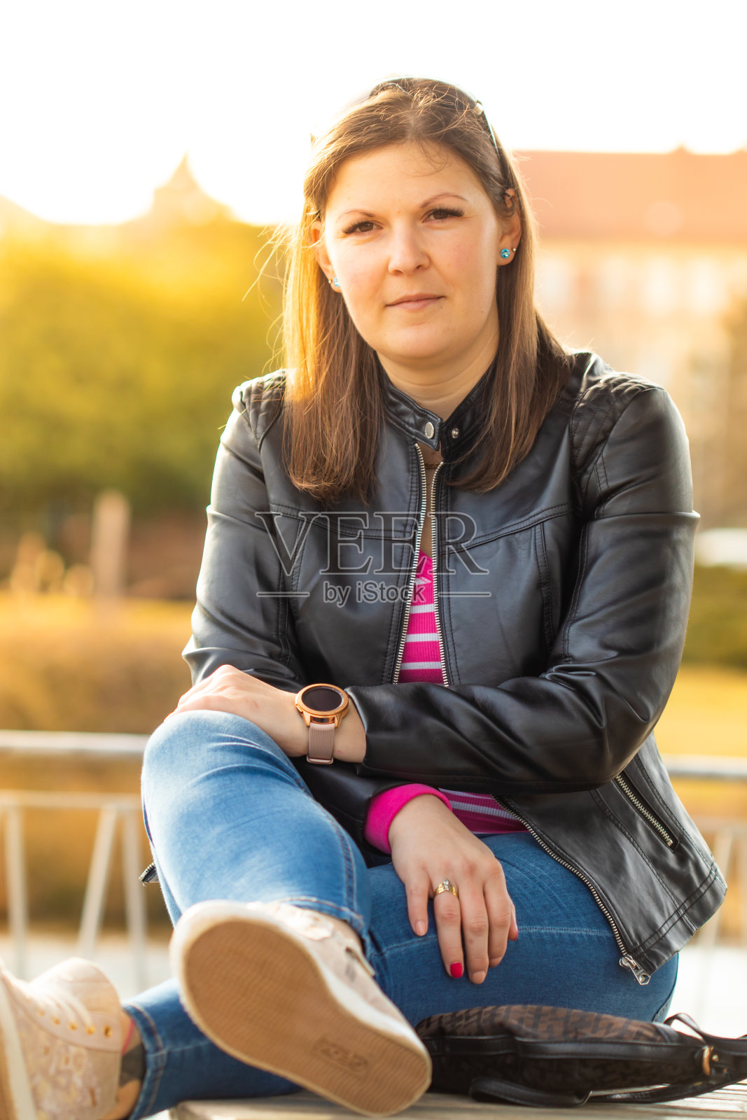 日落时分,一位身穿皮夹克的年轻现代女性的肖像。照片摄影图片