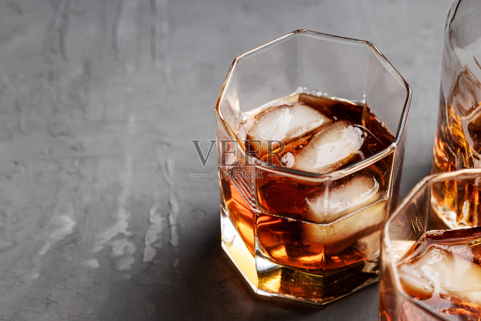 威士忌酒杯,混凝土背景,有复印空间。酒精成瘾概念照片摄影图片