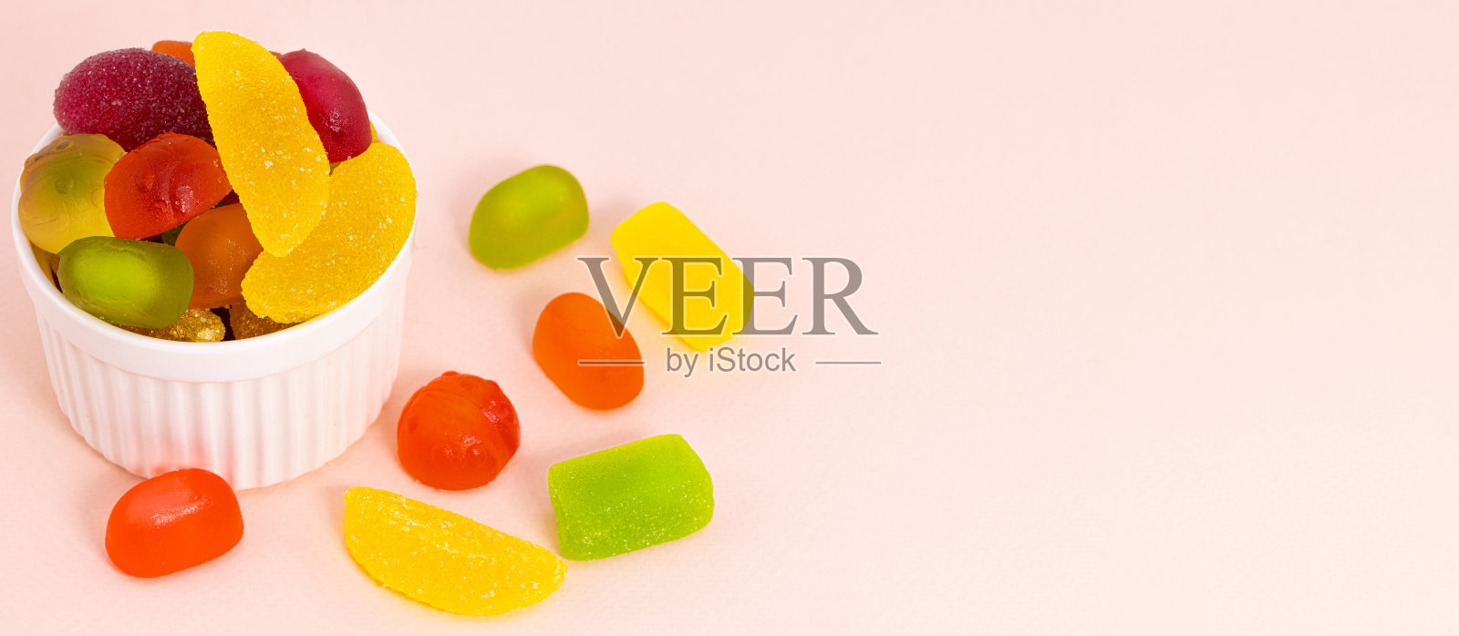 水果软糖,果酱和糖果在米色的背景与复制空间。碗里的彩色糖果照片摄影图片