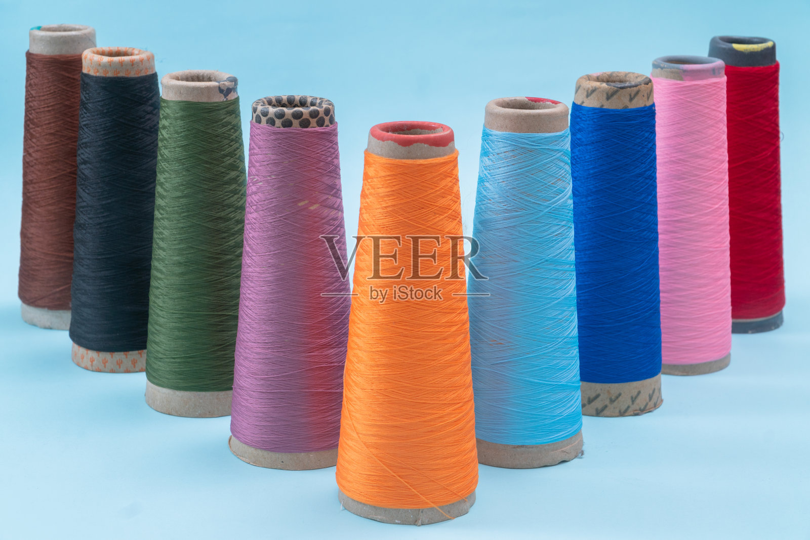 五颜六色的衣服缝纫线的线轴排列成三角形箭头。照片摄影图片