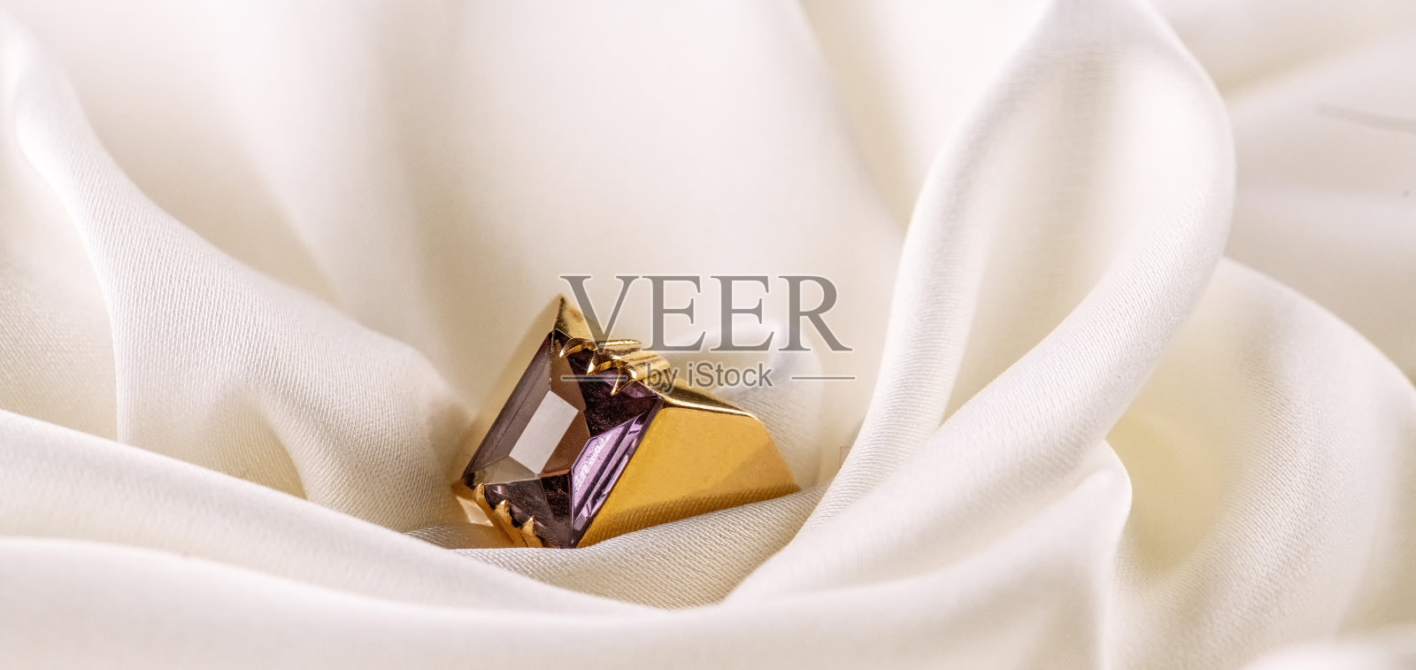 金戒指与翠绿宝石的背景白色丝绸照片摄影图片