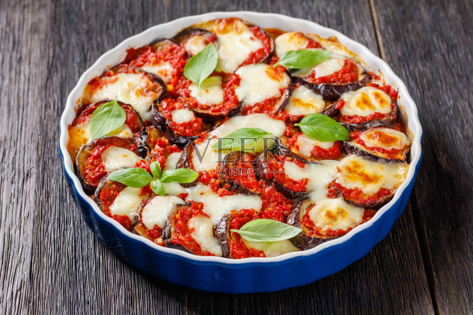 帕尔马干酪(Parmigiana di Melanzane),用番茄沙司、罗勒、帕尔马干酪和马苏里拉奶酪烤茄子,意大利美食,特写镜头照片摄影图片