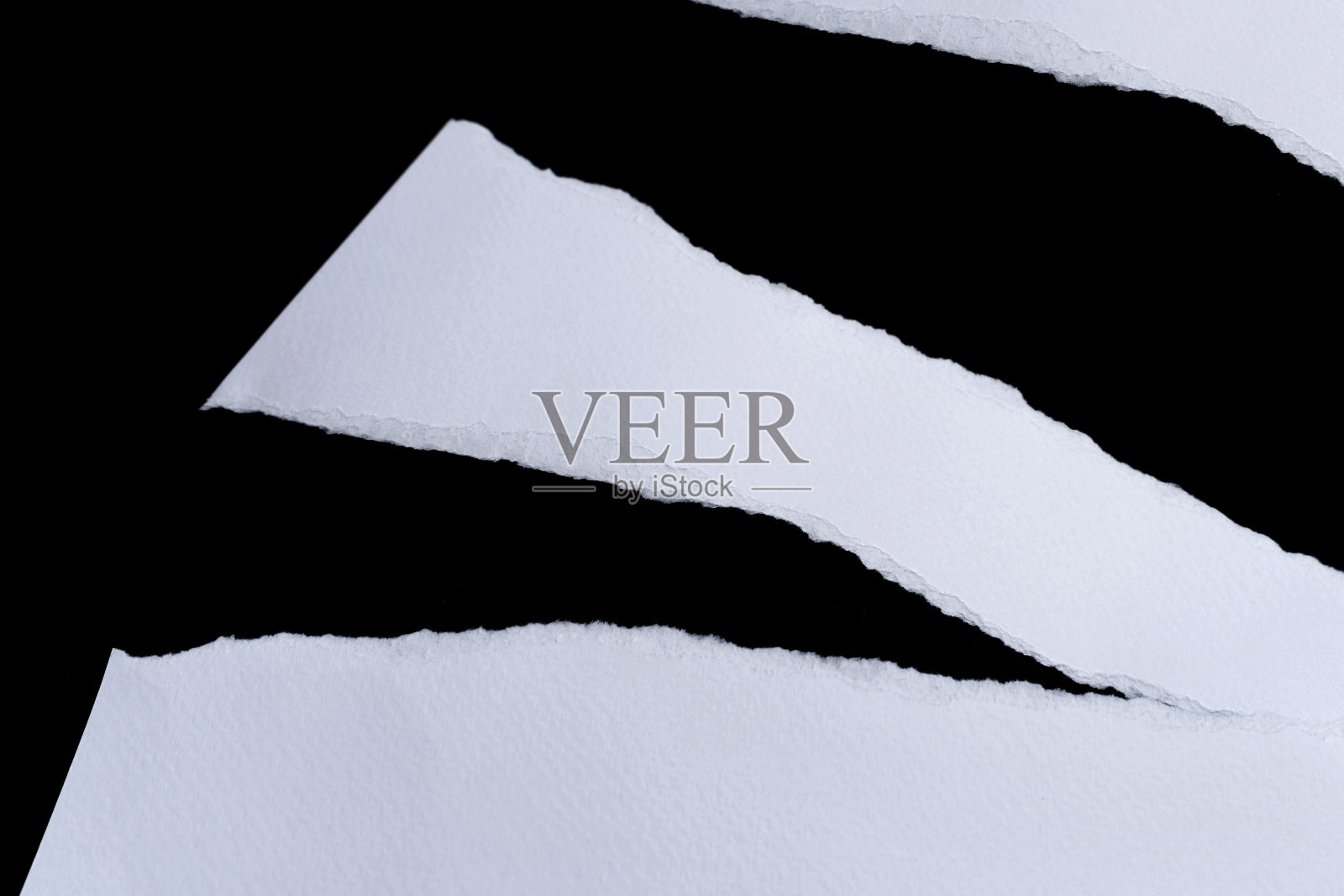 黑色背景的再生纸工艺品棒。白色的纸被撕破或撕裂的纸块孤立在黑色背景与剪切路径。照片摄影图片